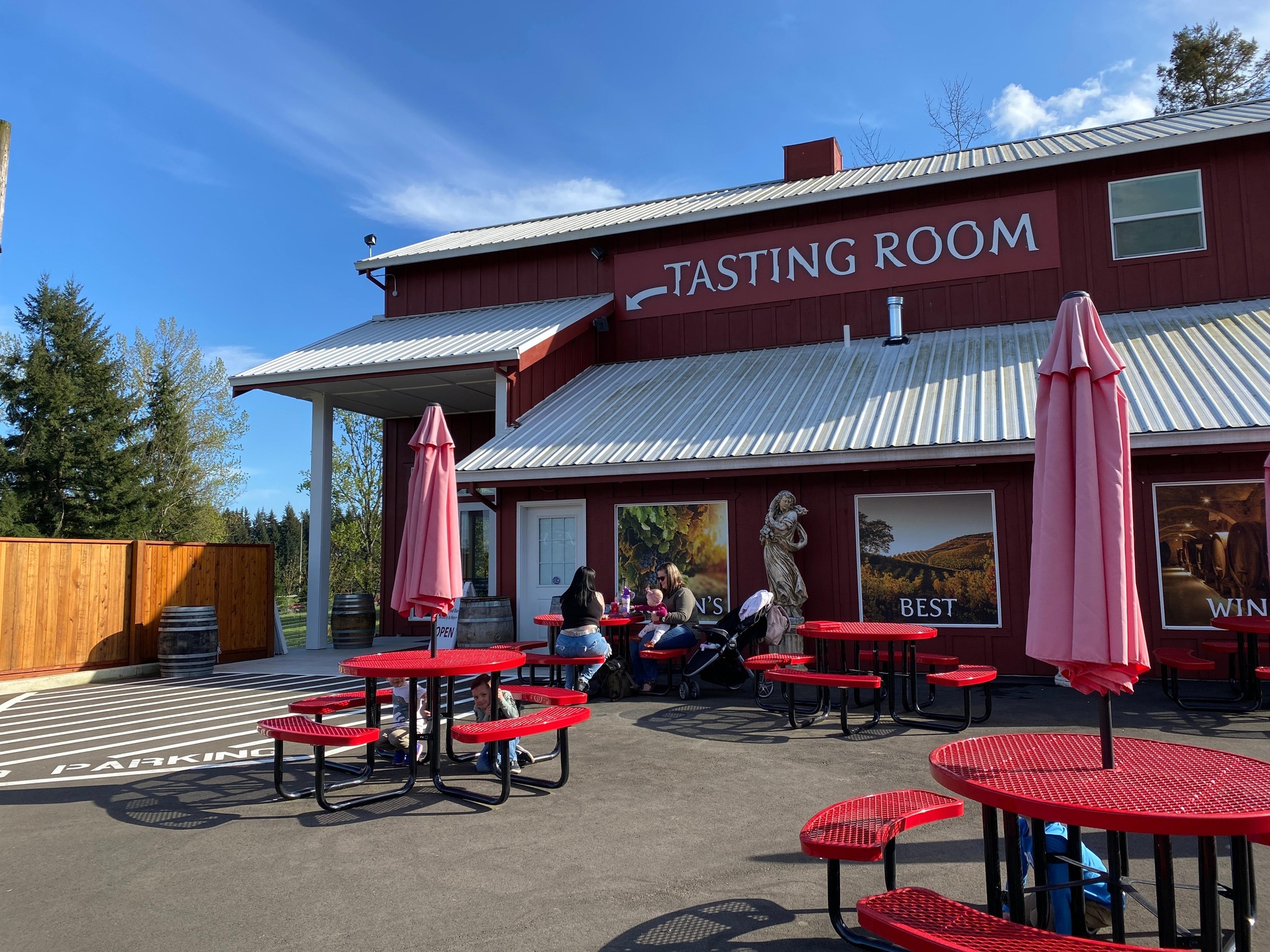 Tasting Room Exterior, Red picnic tables in front of large red barn